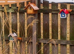 Three birdhouses on a fence